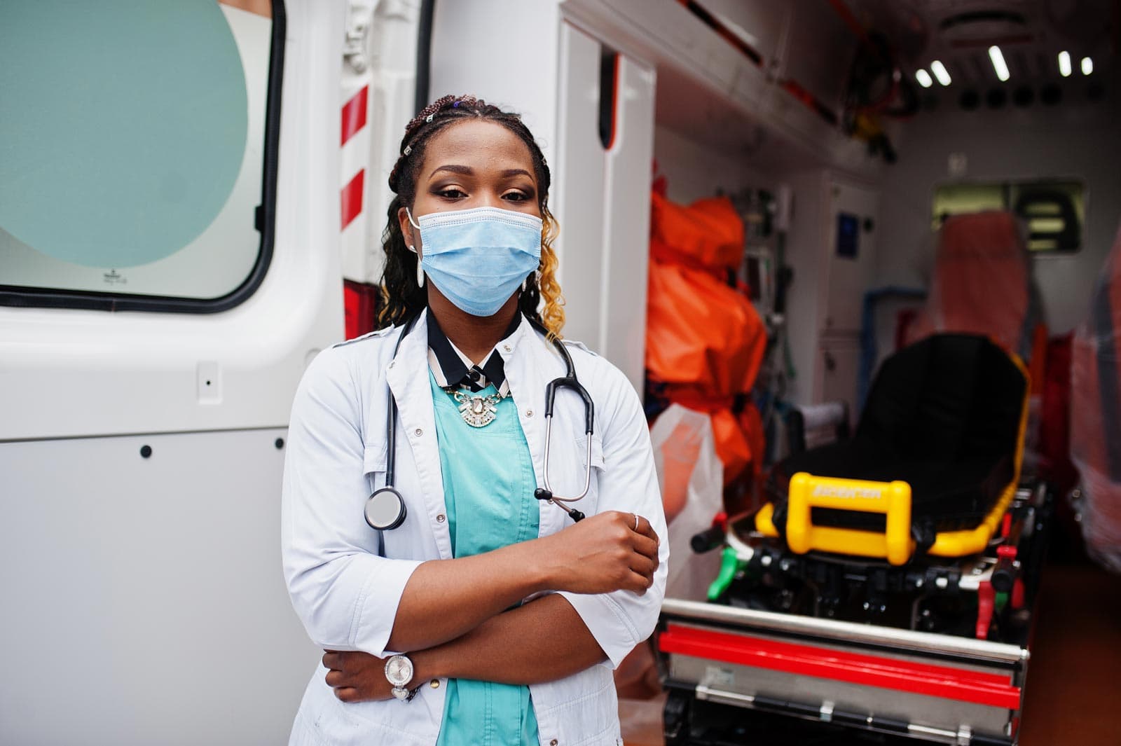 A paramedic in front of an ambulance